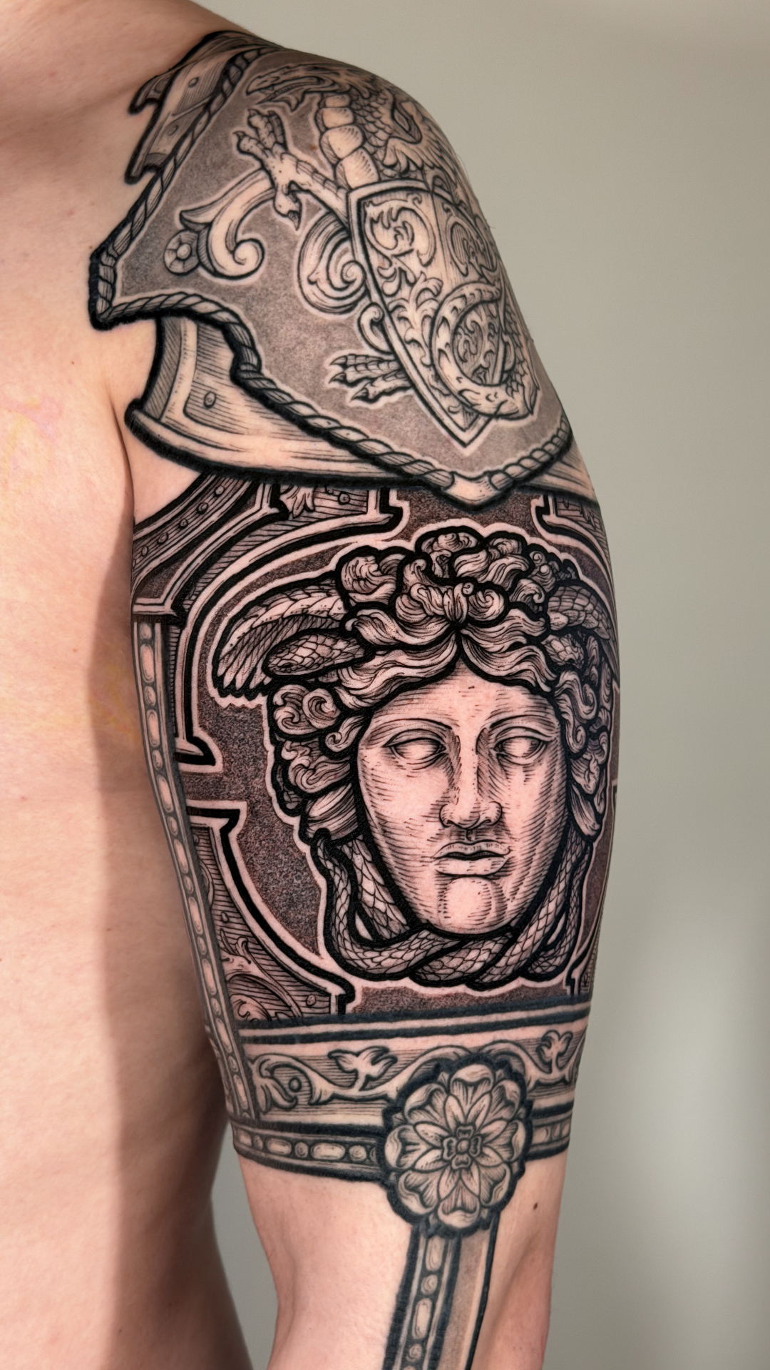 Engraving-style Medusa and armour sleeve tattoo