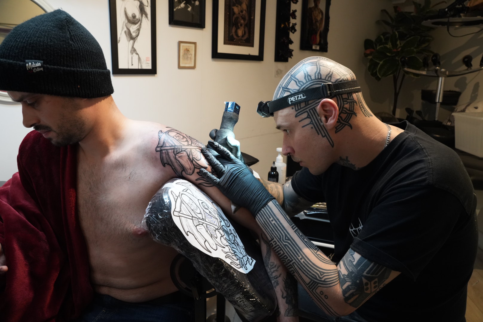 Antonio working on a large engraving-style tattoo