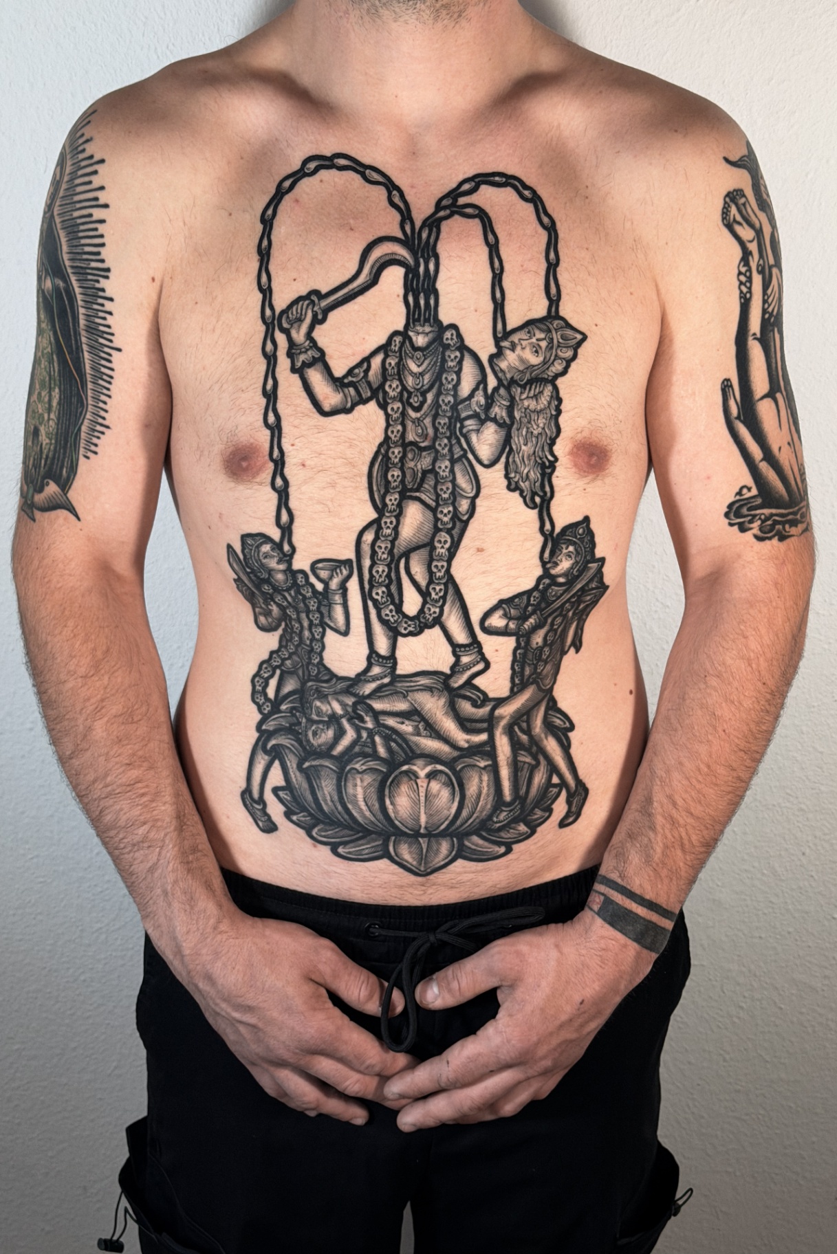 Engraving-style Kali tattoo across the chest and stomach